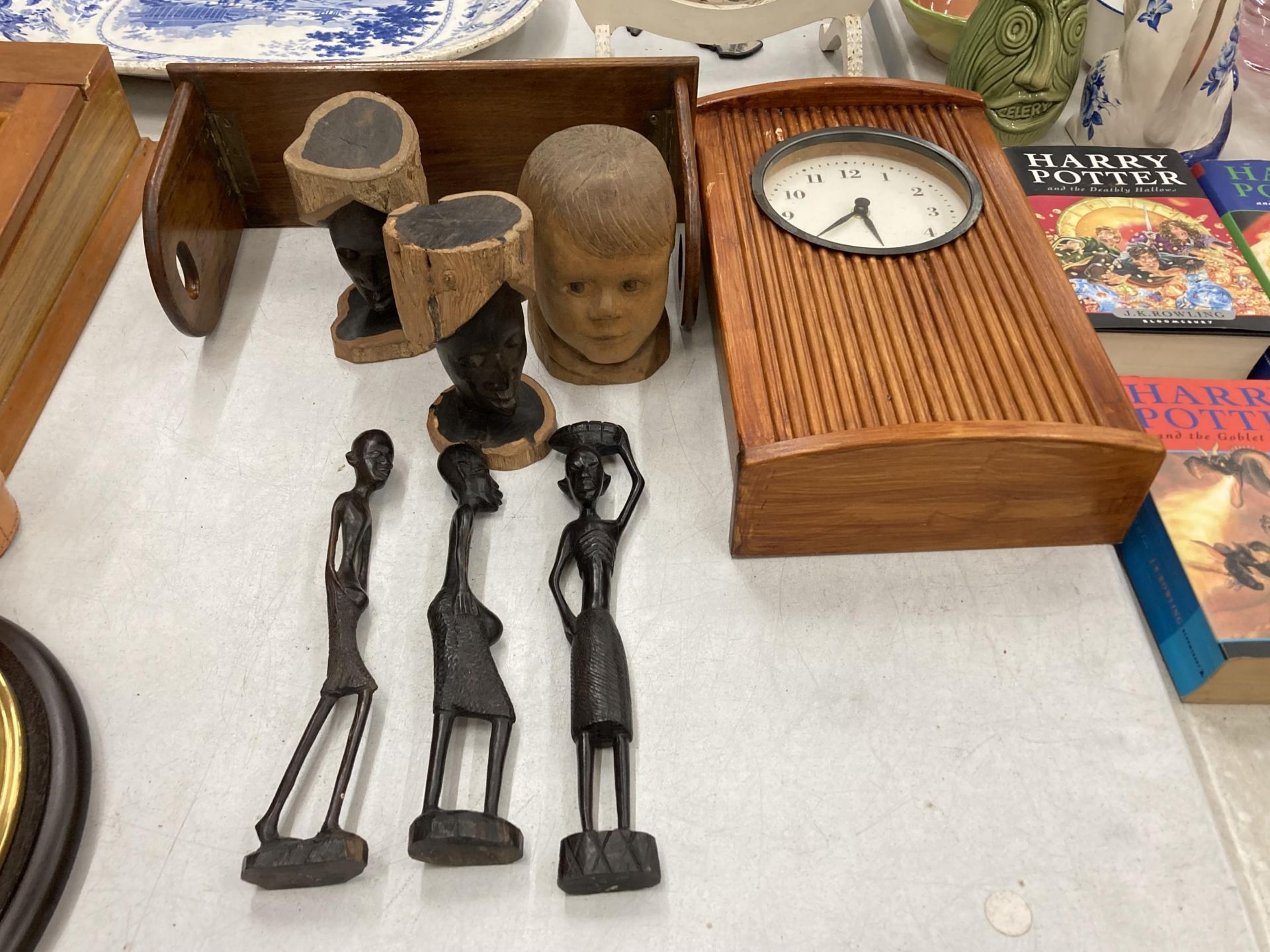 A QUANTITY OF TREEN TO INCLUDE A MANTLE CLOCK, THREE FIGURES, THREE CARVED HEADS AND A SHELF