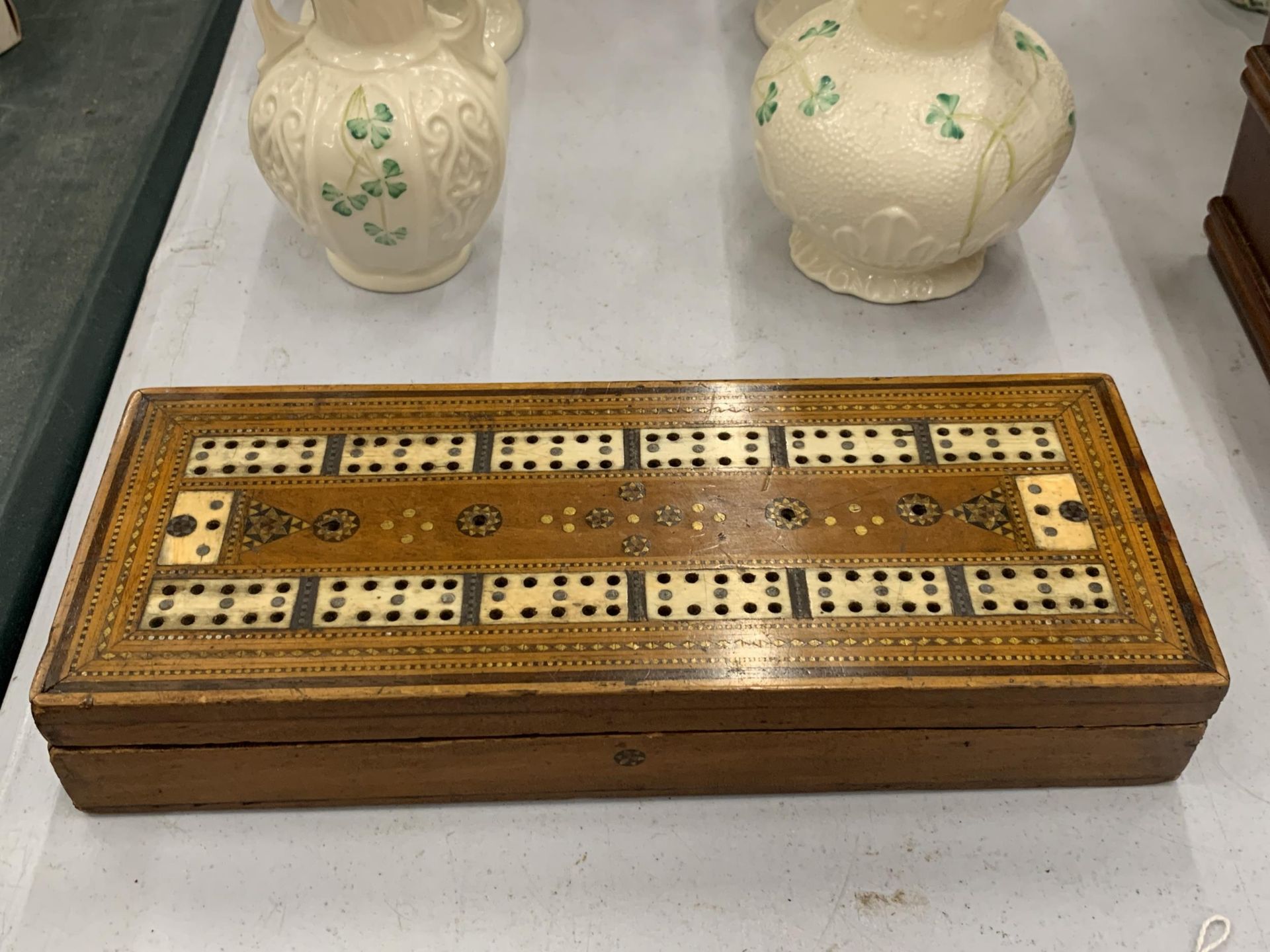 AN MAHOGANY CRIBBAGE BOARD INLAID WITH BONE CROSS BANDING