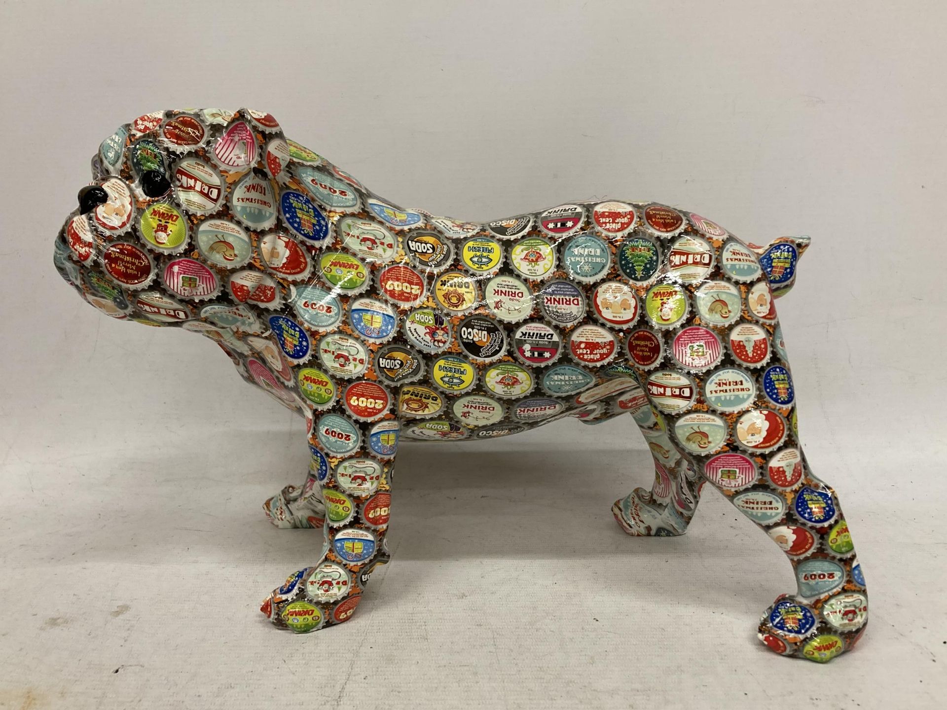 A LARGE BULLDOG WITH CONTINENTAL BOTTLE TOP DECORATION, HEIGHT 26CM, LENGTH 37CM