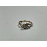 A 9 CARAT GOLD RING WITH TWO DIAMONDS ON A TWIST AND DIAMONDS TO THE SHOULDERS SIZE M