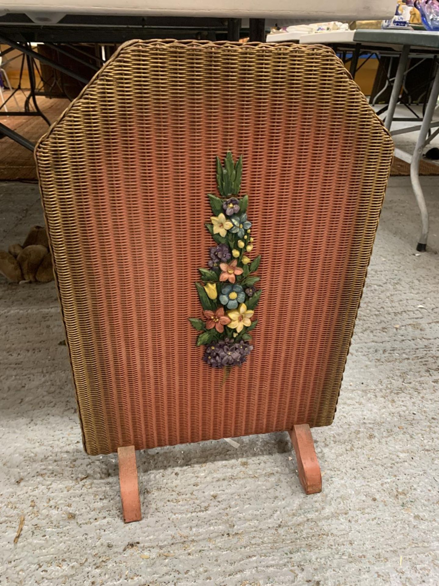 A VINTAGE WOODEN AND BASKET WEAVE FIRE SCREEN, RED WITH FLORAL DECORATION