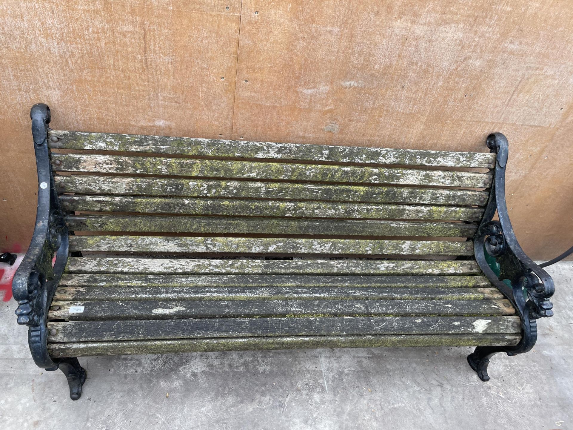 A HEAVY DUTY WOODEN SLATTED GARDEN BENCH WITH A PAIR OF HEAVILY DECORATED CAST IRON BENCH ENDS - Bild 2 aus 3