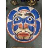 A CARVED WOODEN FACE MASK WITH RED, WHITE AND BLUE DESIGN