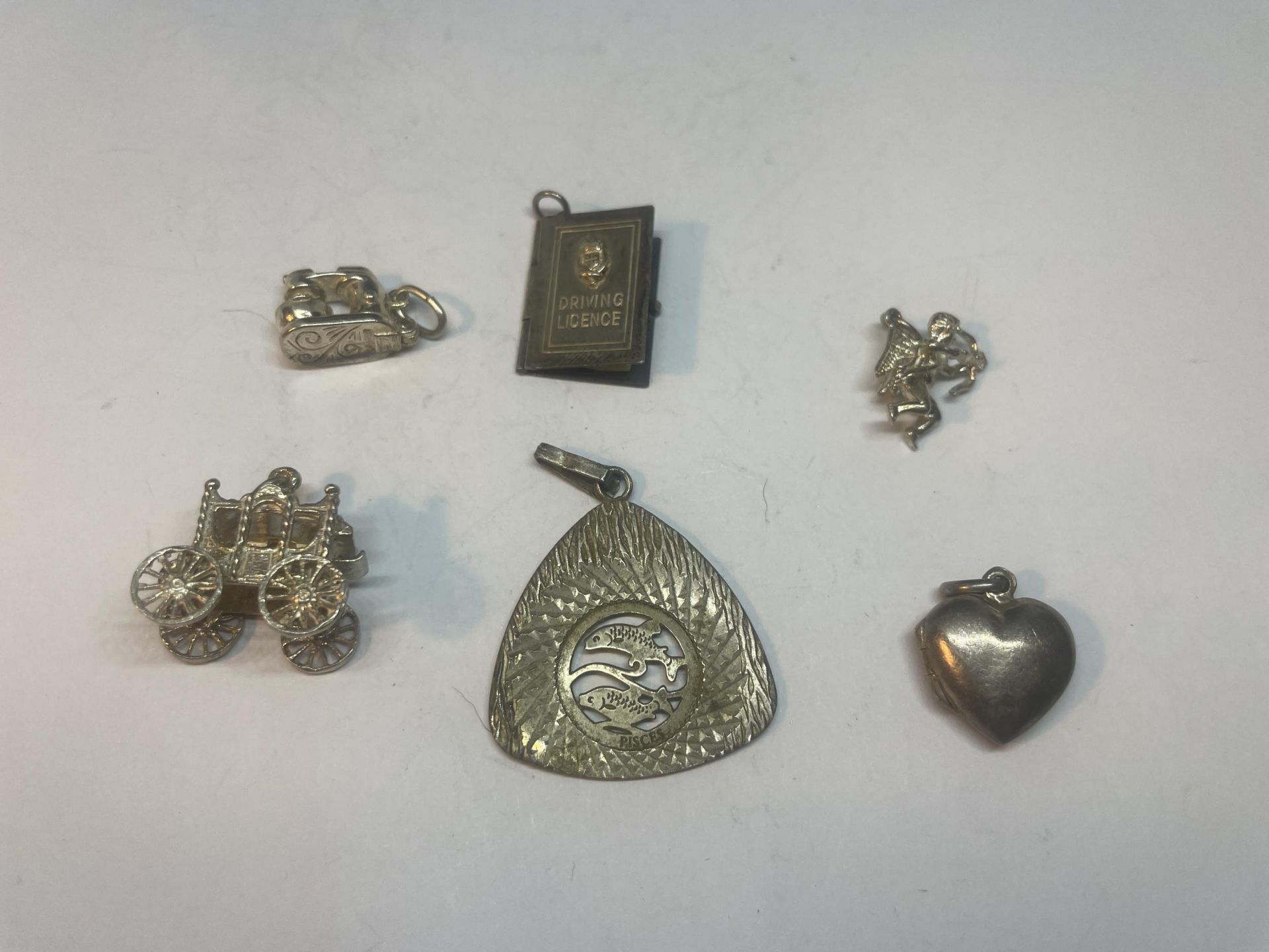 SIX SILVER ITEMS TO INCLUDE FIVE CHARMS AND A PENDANT