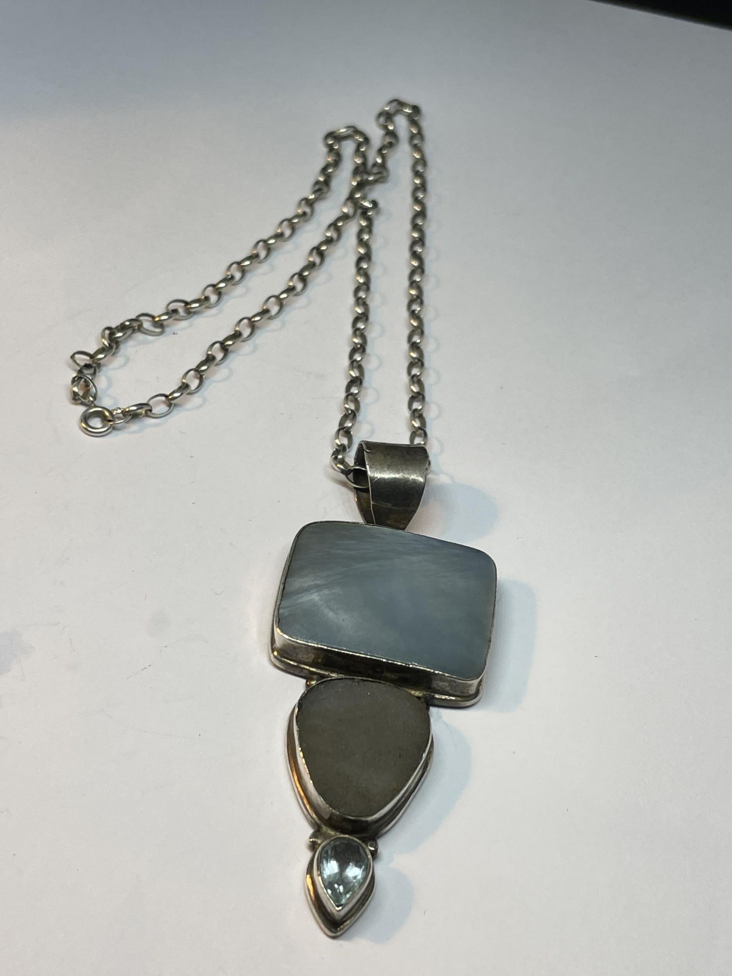 A SILVER NECKLACE WITH LARGE STONE PENDANT