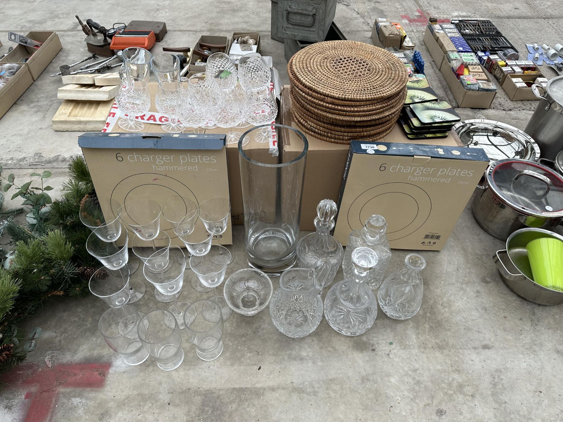 A LARGE ASSORTMENT OF ITEMS TO INCLUDE CHARGER PLATES, CUT BRANDY GLASSES AND CUT GLASS DECANTORS TO