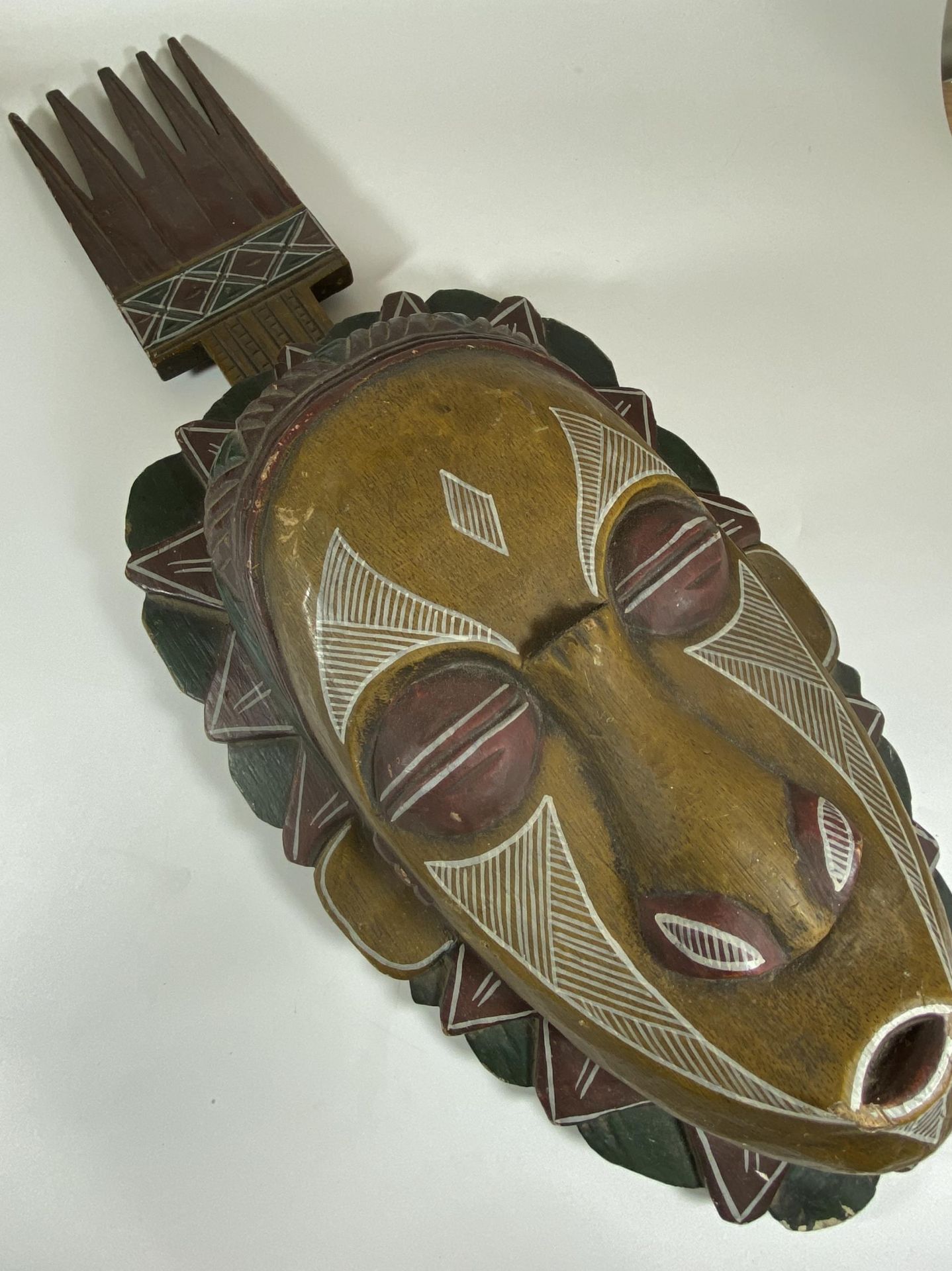 A LARGE VINTAGE AFRICAN TRIBAL WOODEN MASK WITH PAINTED DESIGN, LENGTH 65CM