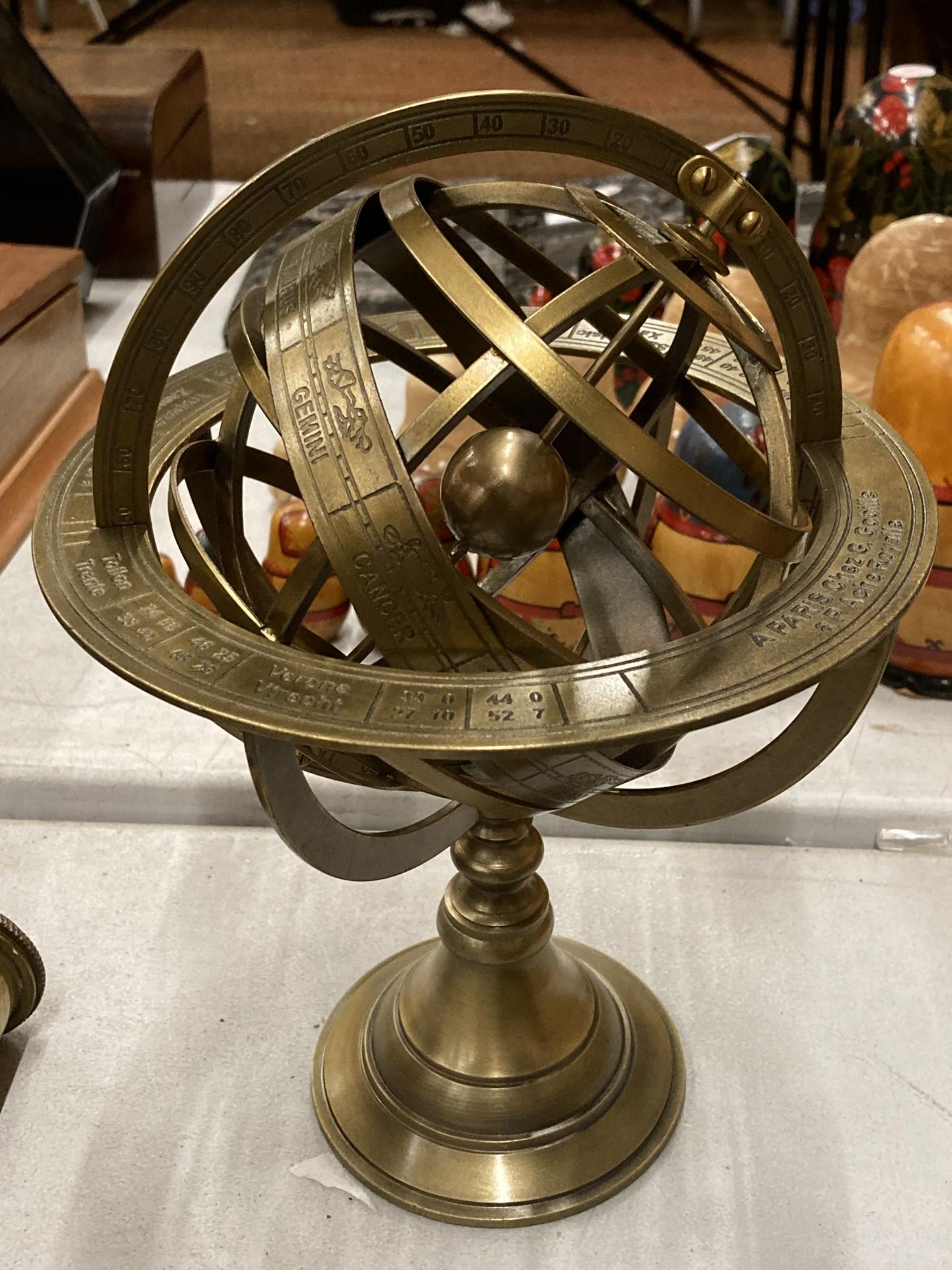 A BRASS REVOLVING GLOBE STYLE DESK COMPASS WITH BIRTH SIGNS