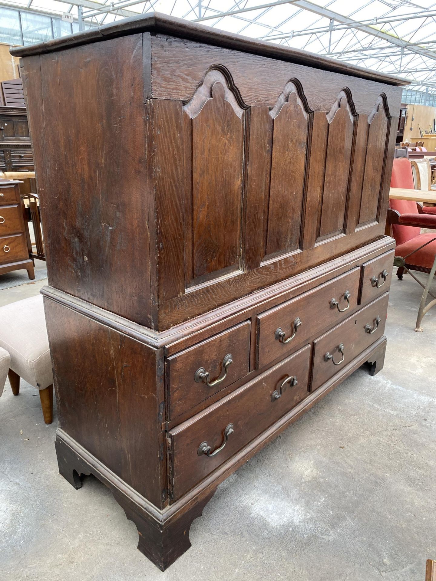 A GEORGIAN OAK FOUR PANEL MULE CHEST WITH FIVE DRAWERS TO THE BASE, 52" WIDE, ON BRACKET FEET