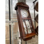 AN OAK CASED CHIMING WALL CLOCK