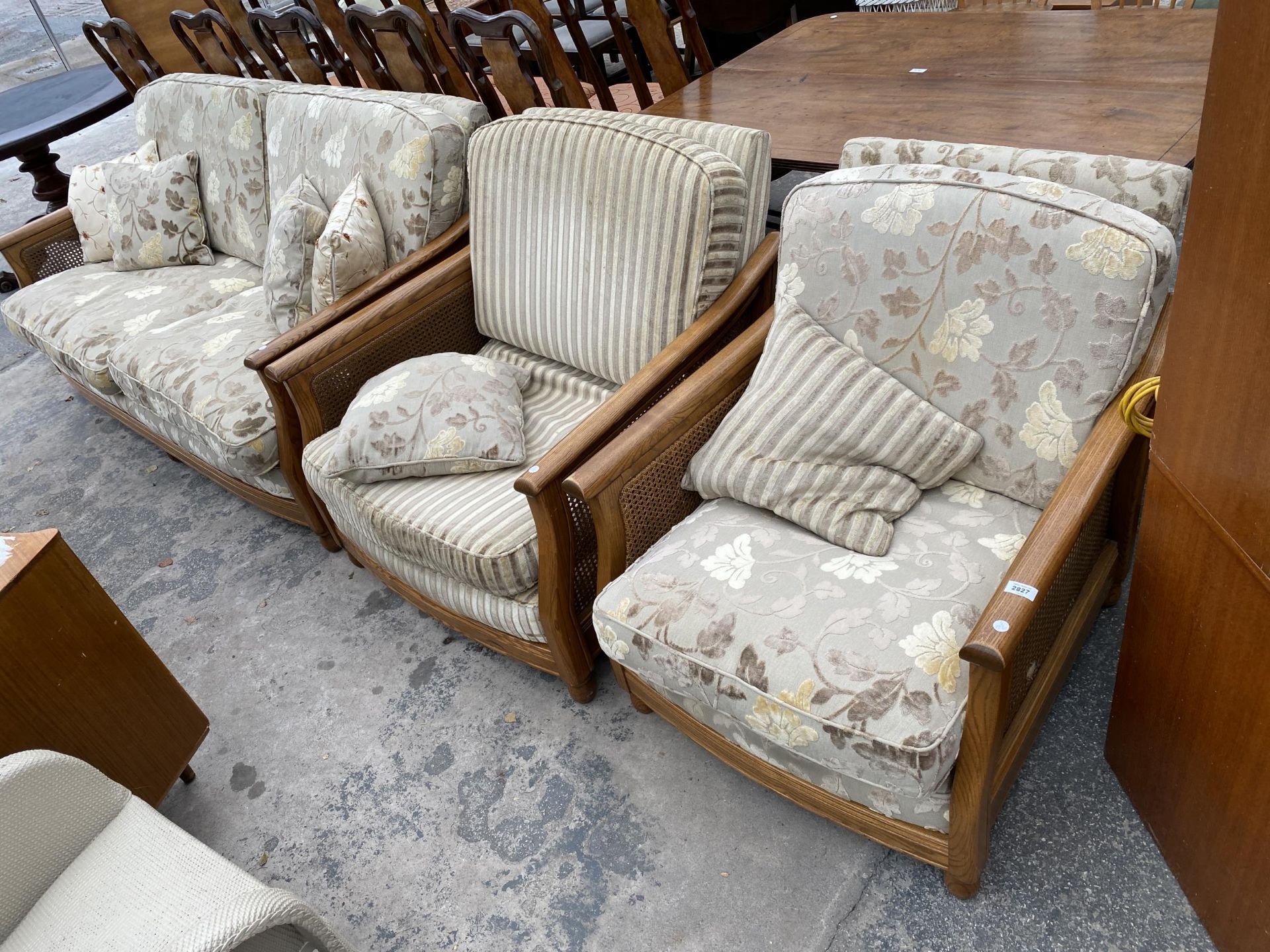 AN ERCOL BERGERE FOUR PIECE SUITE COMPRISING SETTEE, TWO EASY CHAIRS AND A STOOL