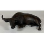 AN ANTIQUE CHINESE HEAVY SOLID BRONZE MODEL OF AN OX LYING DOWN, LENGTH 21CM