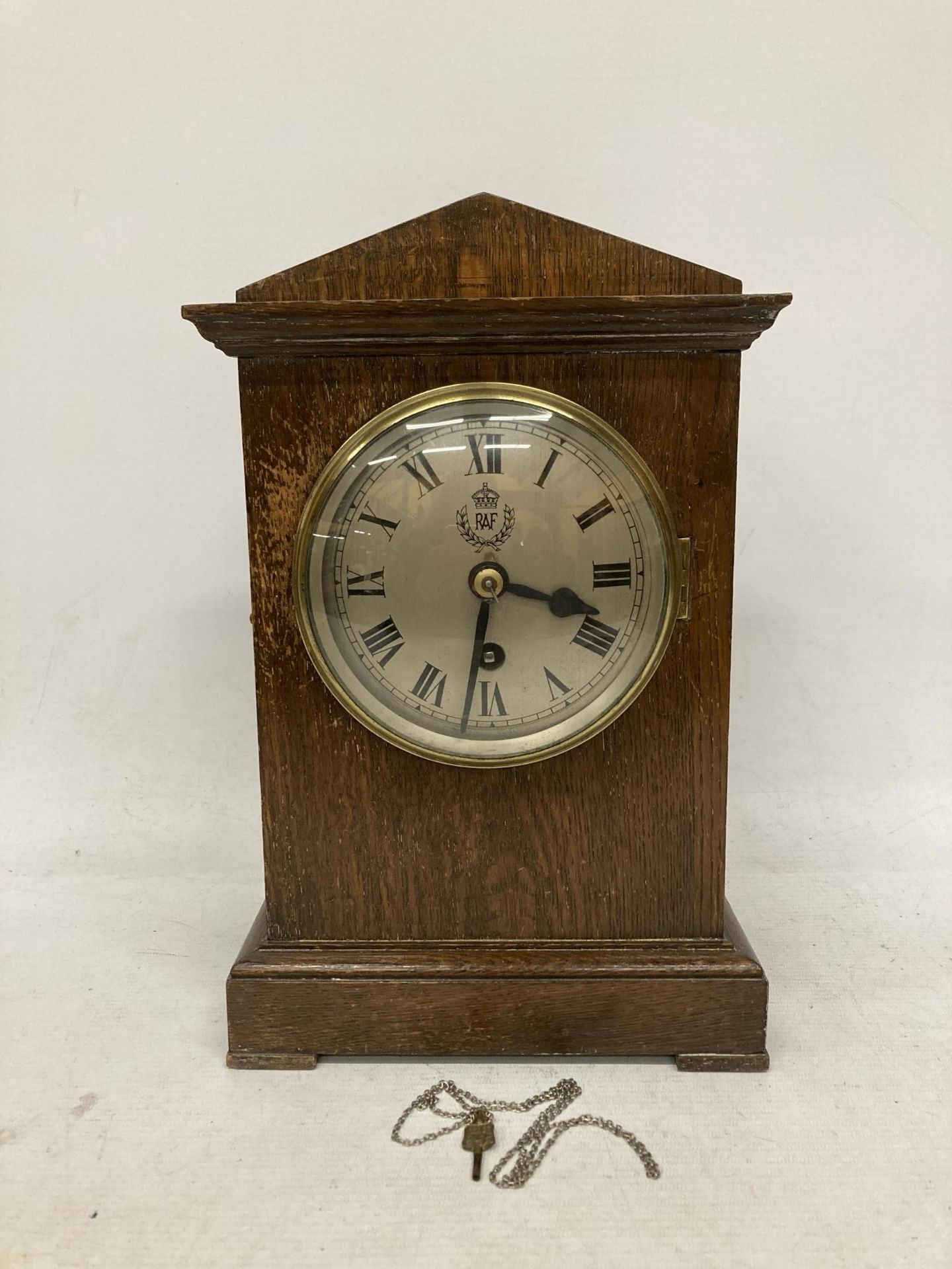 A VINTAGE OAK CASED MANTLE CLOCK WITH 'RAF' MONOGRAM TO DIAL, WITH PENDULUM