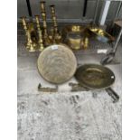 A LARGE ASSORTMENT OF BRASS ITEMS TO INCLUDE PANS, CHARGERS,A GONG AND CANDLE STICKS ETC