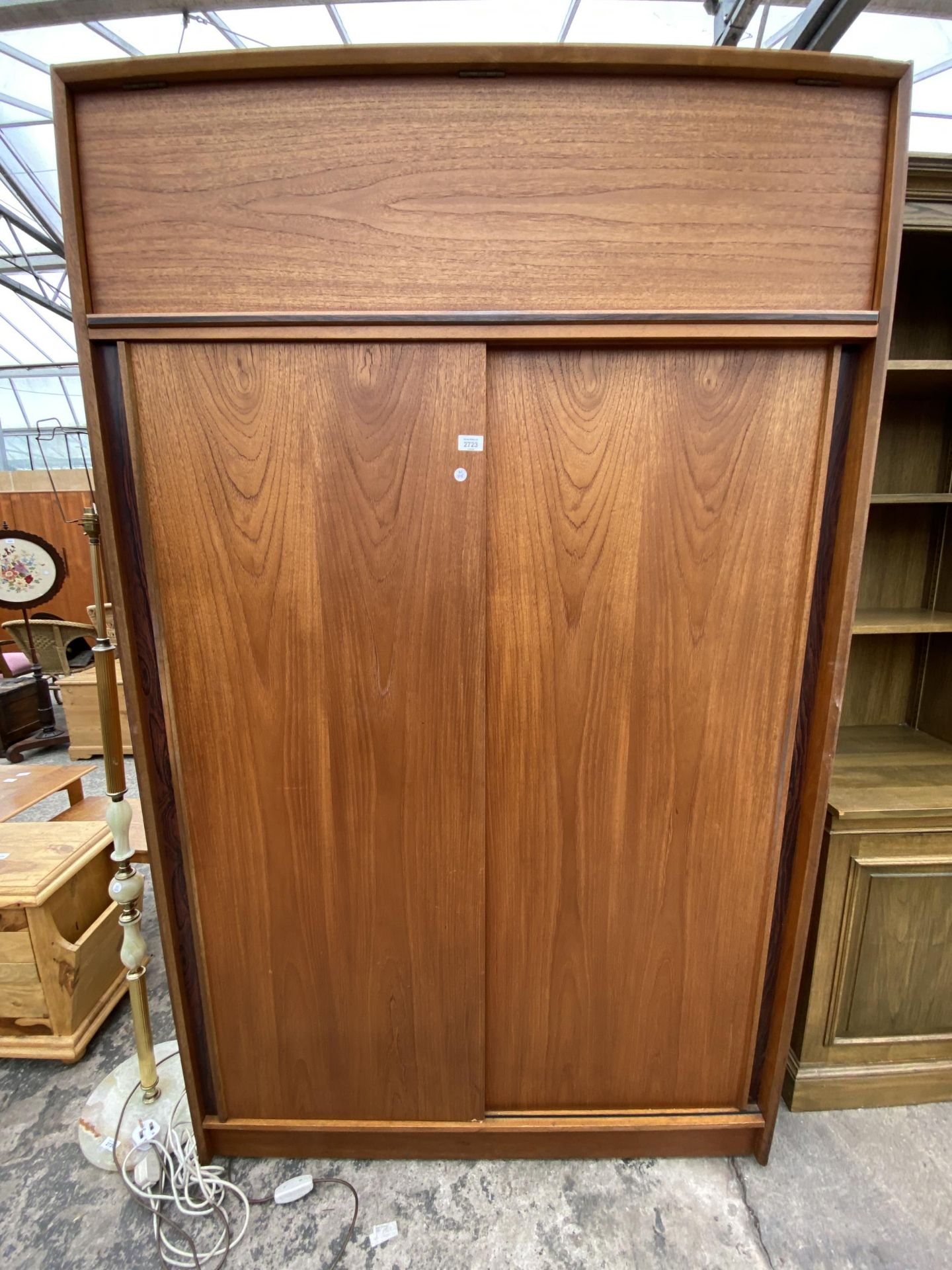 A RETRO TEAK AUSTINSUITE SLIDING TWO DOOR WARDROBE WITH TOP STORAGE SECTION, 48" WIDE, ON CASTERS
