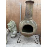 A RECONSTITUTED STONE GARDEN CHIMENEA WITH METAL STAND