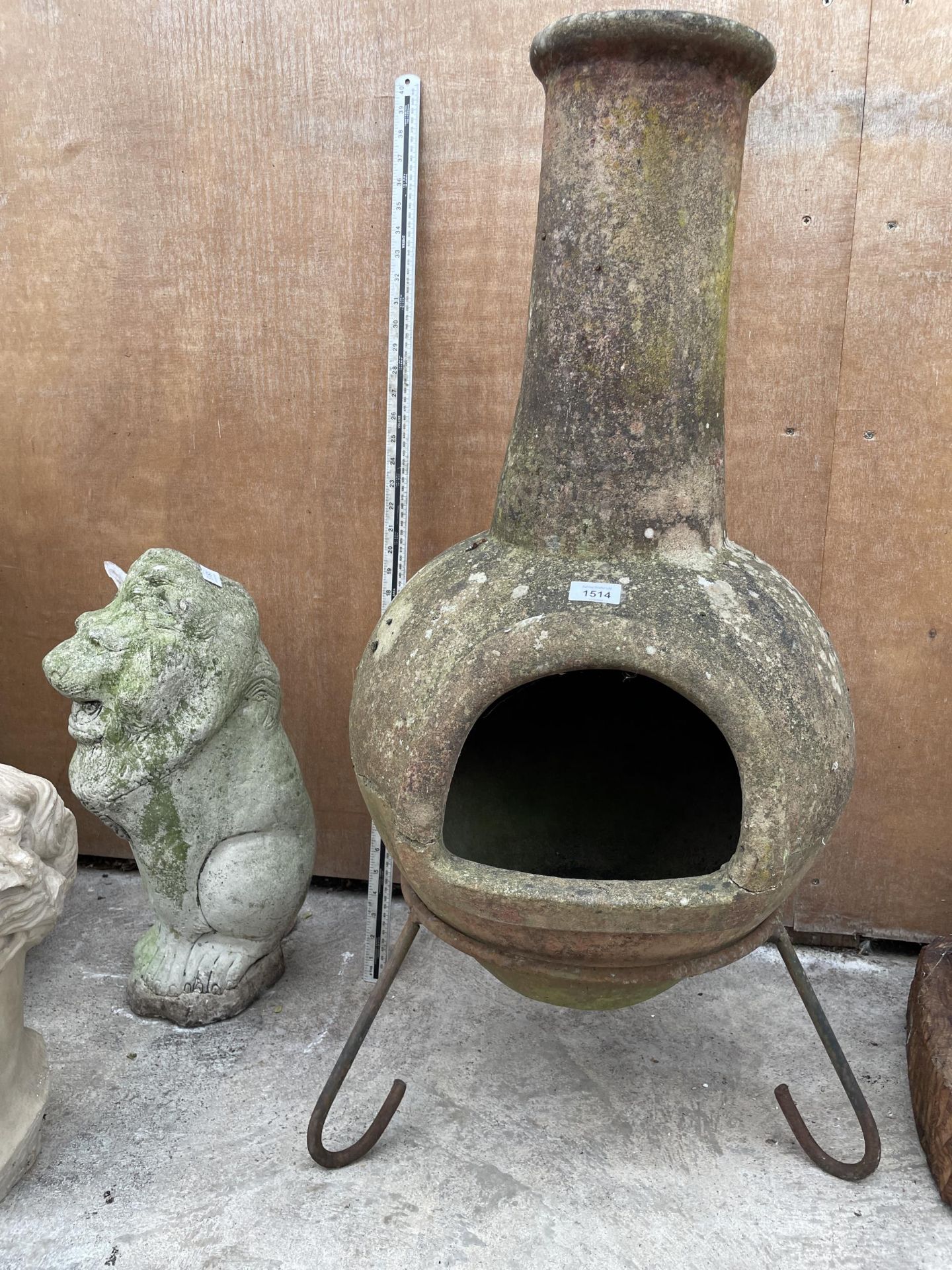 A RECONSTITUTED STONE GARDEN CHIMENEA WITH METAL STAND