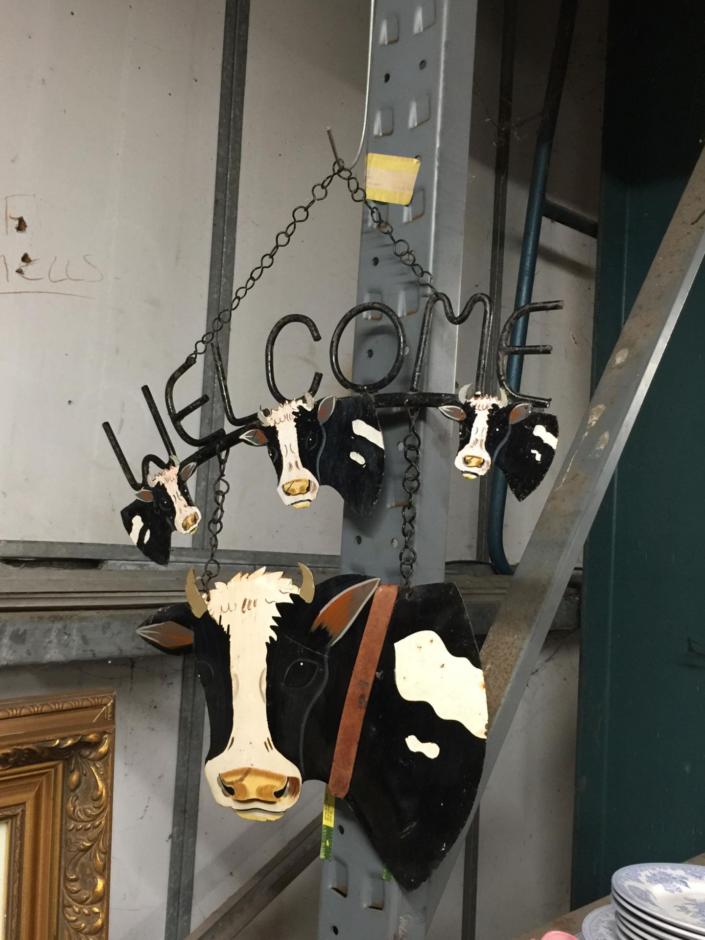 A METAL COW DESIGN HANGING WELCOME SIGN