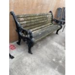 A HEAVY DUTY WOODEN SLATTED GARDEN BENCH WITH A PAIR OF HEAVILY DECORATED CAST IRON BENCH ENDS