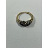AN 18 CARAT GOLD RING WITH TWO AQUAMARINES DIVIDED BY A TWIST OF DIAMONDS SIZE M/N