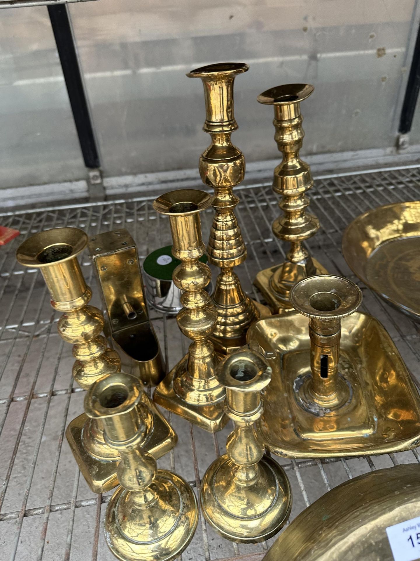 A LARGE ASSORTMENT OF BRASS ITEMS TO INCLUDE PANS, CHARGERS,A GONG AND CANDLE STICKS ETC - Image 2 of 4