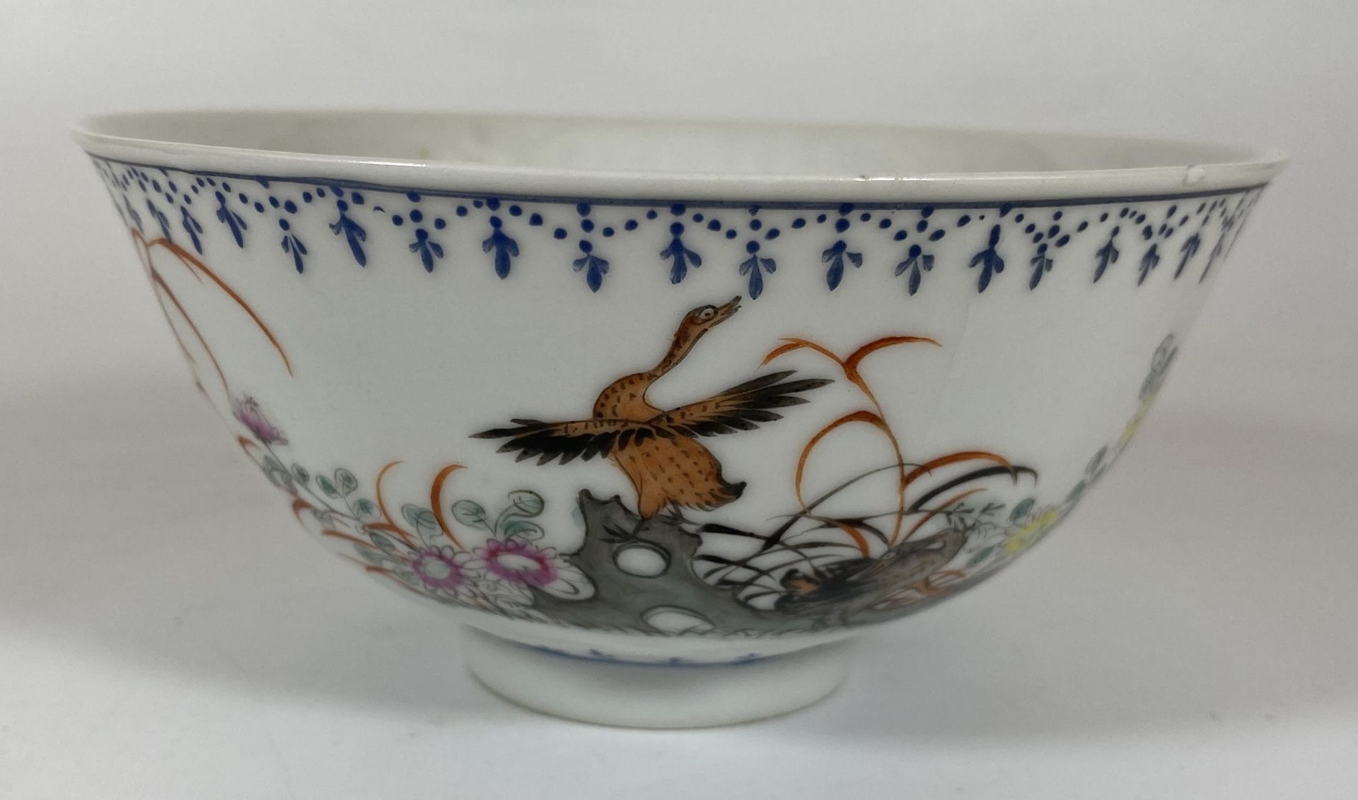 AN EARLY 20TH CENTURY CHINESE QING PORCELAIN BOWL WITH DUCK IN FLIGHT DECORATION, QIANLONG MARK TO