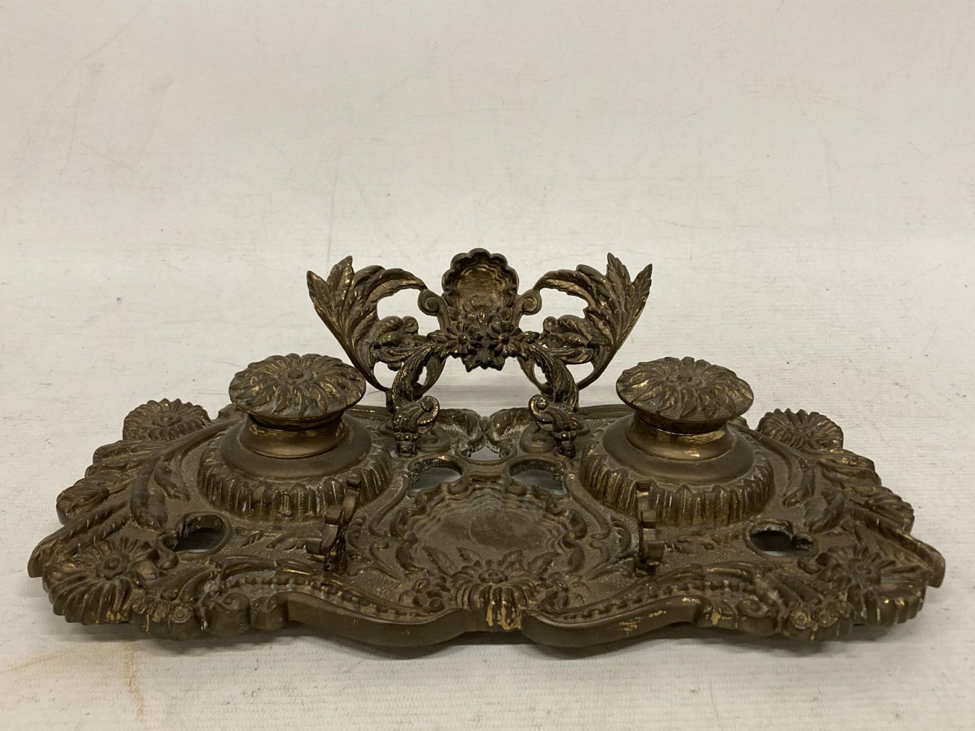 A VINTAGE, POSSIBLY FRENCH, FLORAL DESIGN BRASS DOUBLE INKWELL STAND