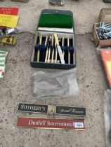 A CASED SET OF BUTTER KNIVES AND TWO SIGNS TO INCLUDE DUNHILL ETC