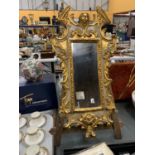 A VINTAGE STYLE GILT MIRROR IN AN ORNATE FRAME, 57CM X 30CM PLUS AN EASEL