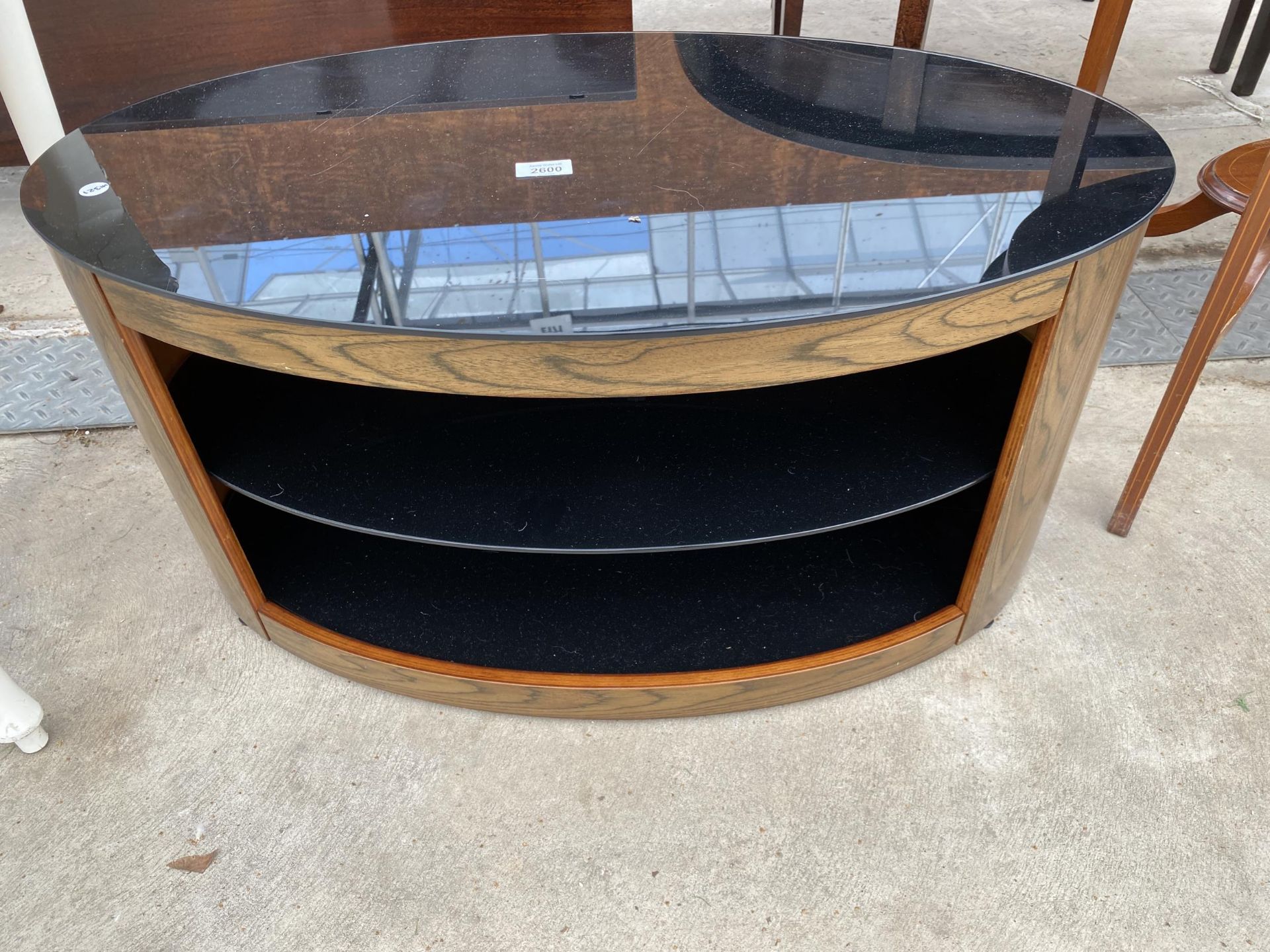 A MODERN OVAL TV STAND WITH THREE TIER GLASS SHELVES