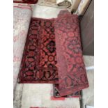 A RED PATTERNED FRINGED RUG