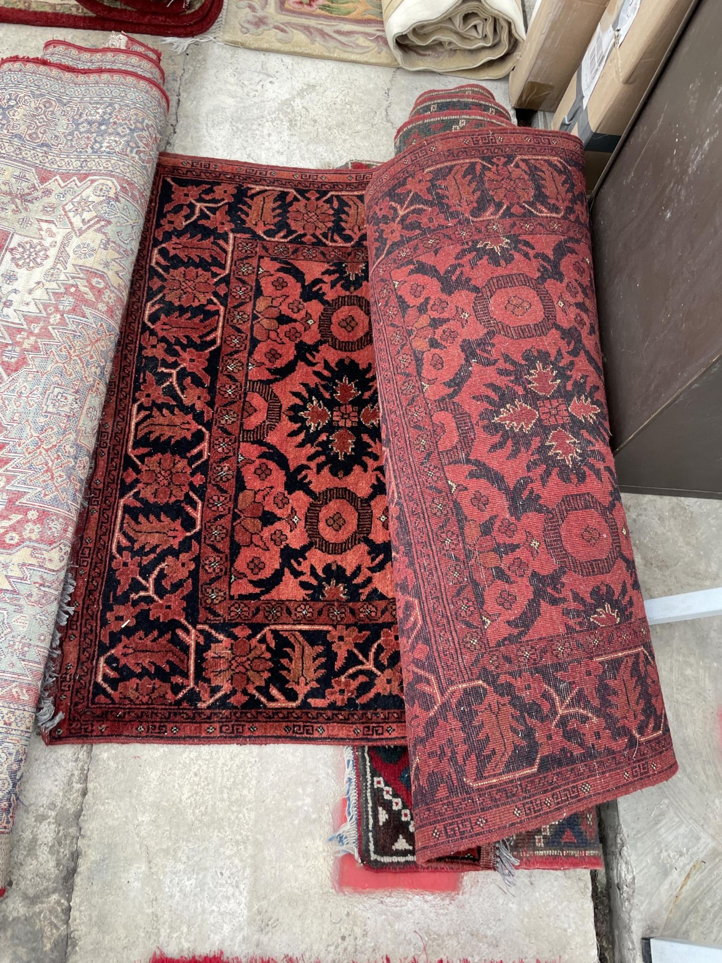 A RED PATTERNED FRINGED RUG