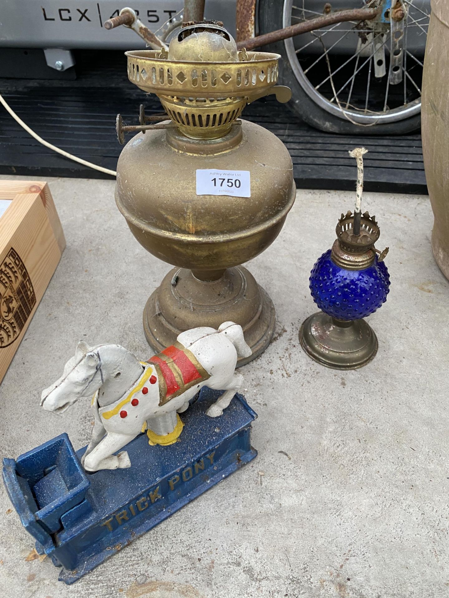 AN ASSORTMENT OF ITEMS TO INCLUDE TWO OIL LAMPS AND A CAST TRICK PONY MONEY BOX