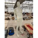 A FIBREGLASS MALE MANEQUIN ON A GLASS STAND