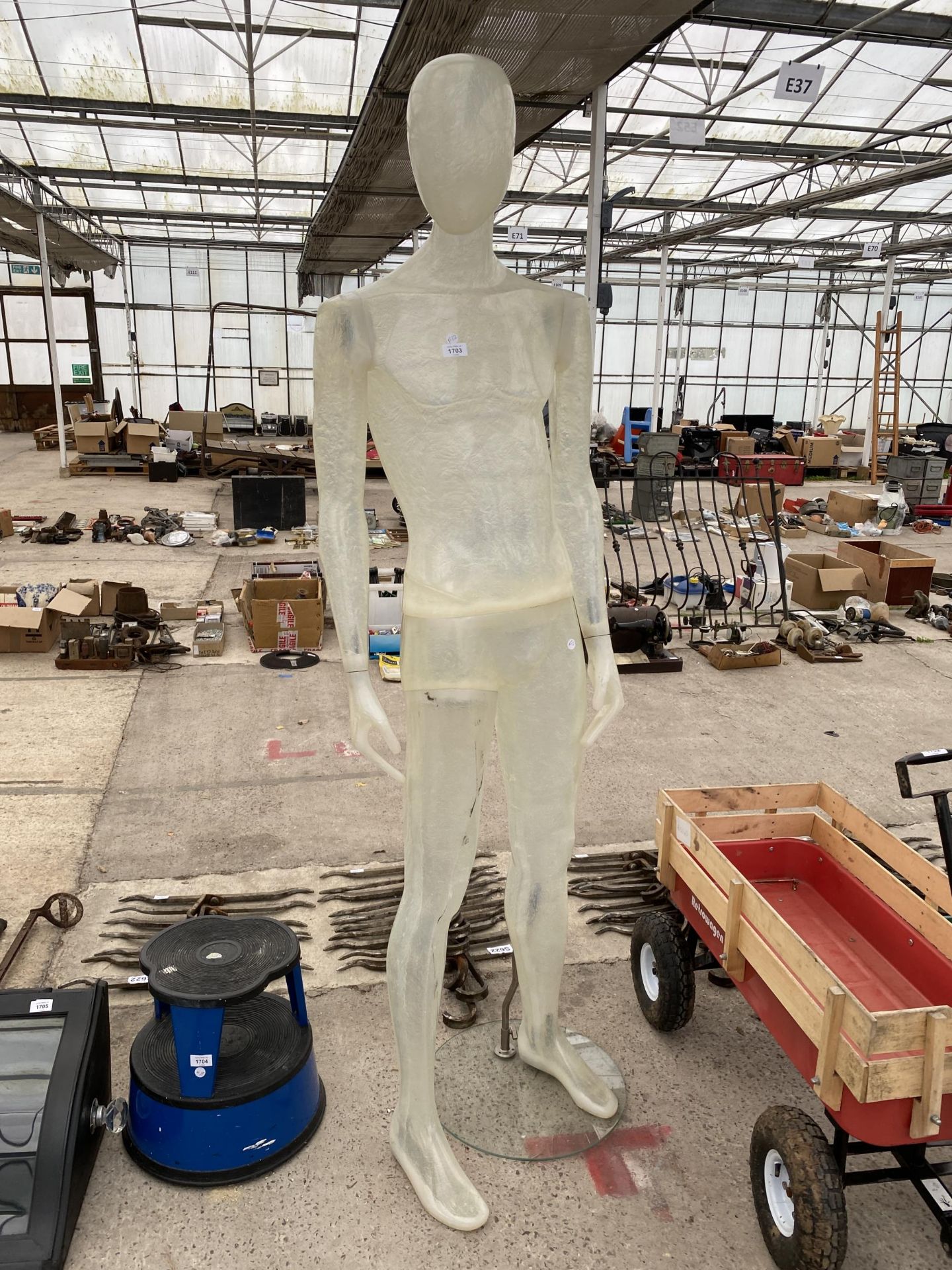 A FIBREGLASS MALE MANEQUIN ON A GLASS STAND
