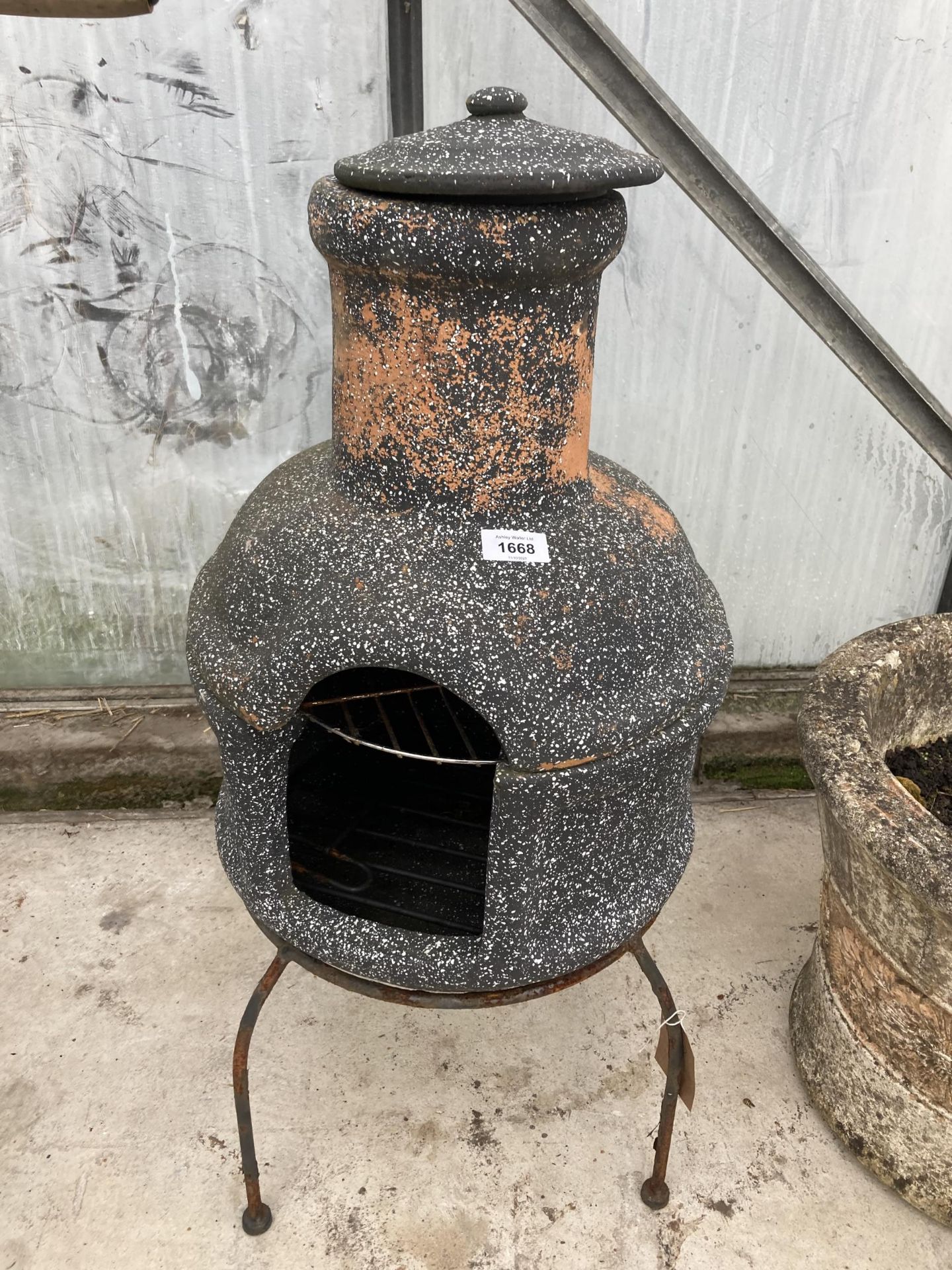 A GARDEN STOVE CHIMiNEA WITH TRIPOD STAND