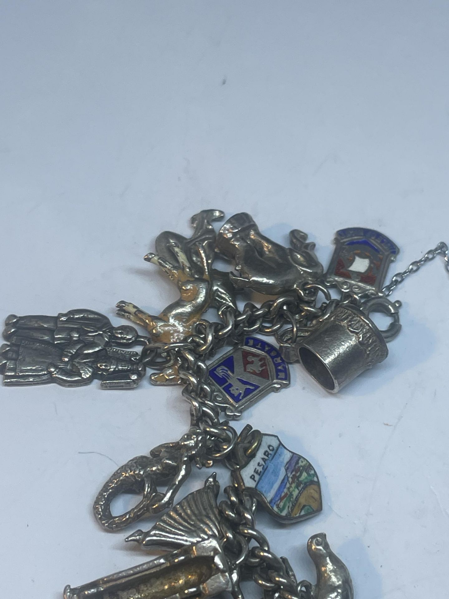 A SILVER CHARM BRACELET WITH TWENTY FIVE CHARMS AND A HEART PADLOCK - Image 2 of 4