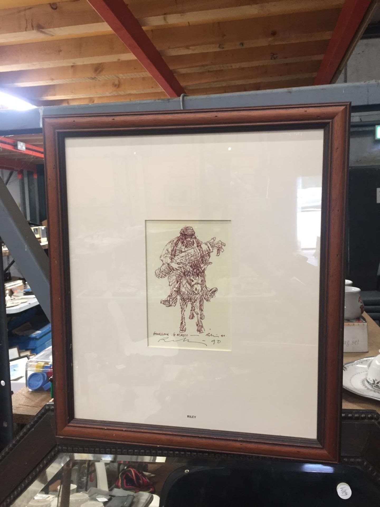 A FRAMED PRINT OF A MAN ON A DONKEY CARRYING GOLF CLUBS, SIGNED RILEY '90