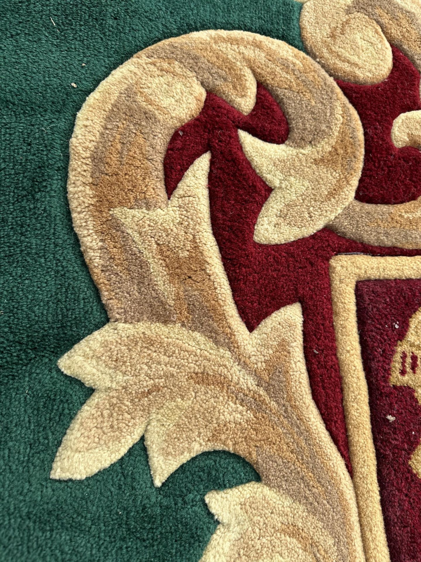 A GREEN AND RED PURE WOOL RUG WITH ARMORIAL CREST - INCLUDES SEVEN MATCHING CURTAIN TIE BACKS - - Image 4 of 6