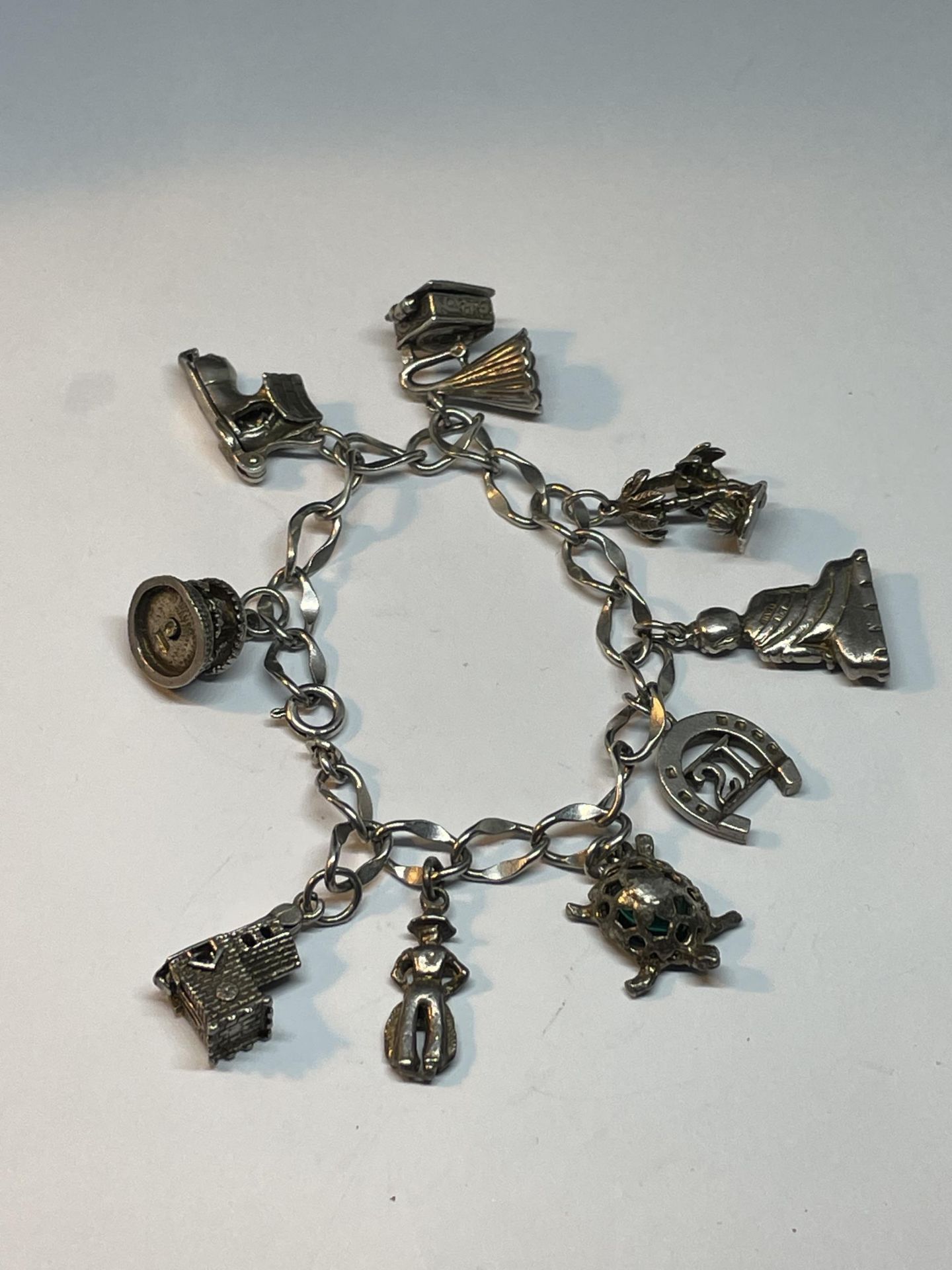 A SILVER CHARM BRACELET WITH NINE CHARMS