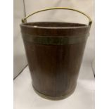 A TALL VINTAGE WOODEN BUCKET WITH BRASS HANDLE AND BANDING