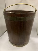 A TALL VINTAGE WOODEN BUCKET WITH BRASS HANDLE AND BANDING