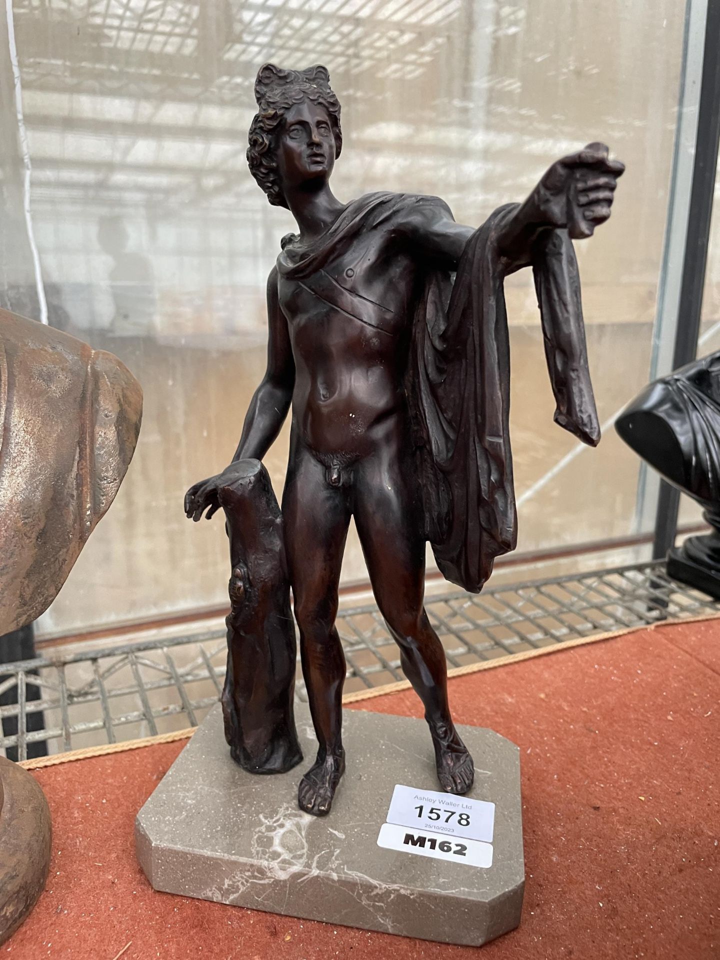 A BRONZE FIGURE OF A MALE ON A MRBLE BASE