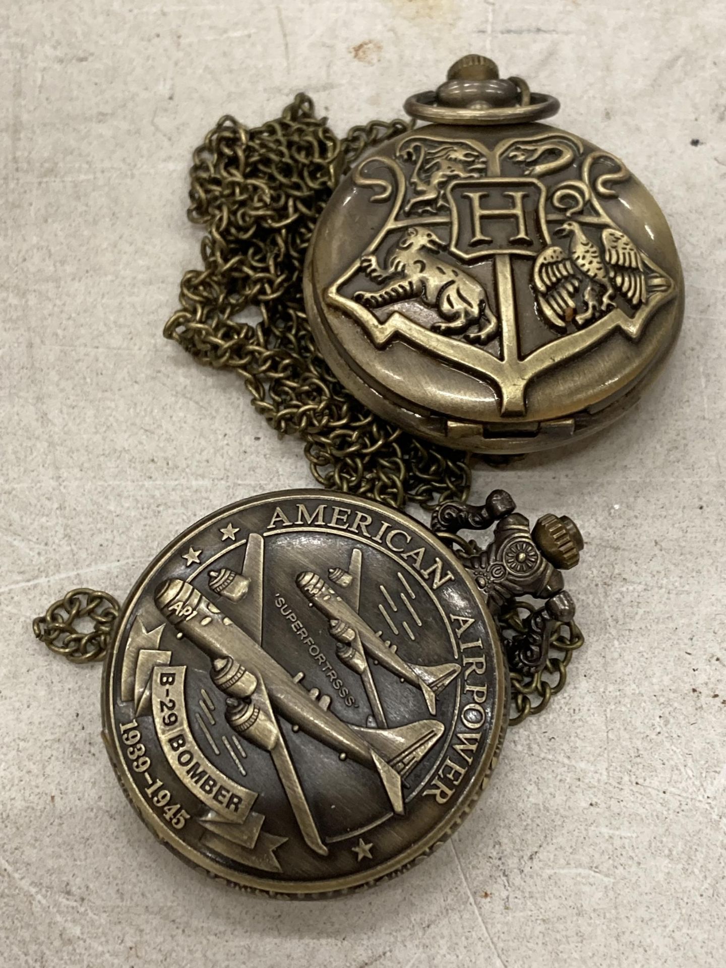 TWO POCKET WATCHES WITH IMAGES OF A USA BOMBER AND A COAT OF ARMS