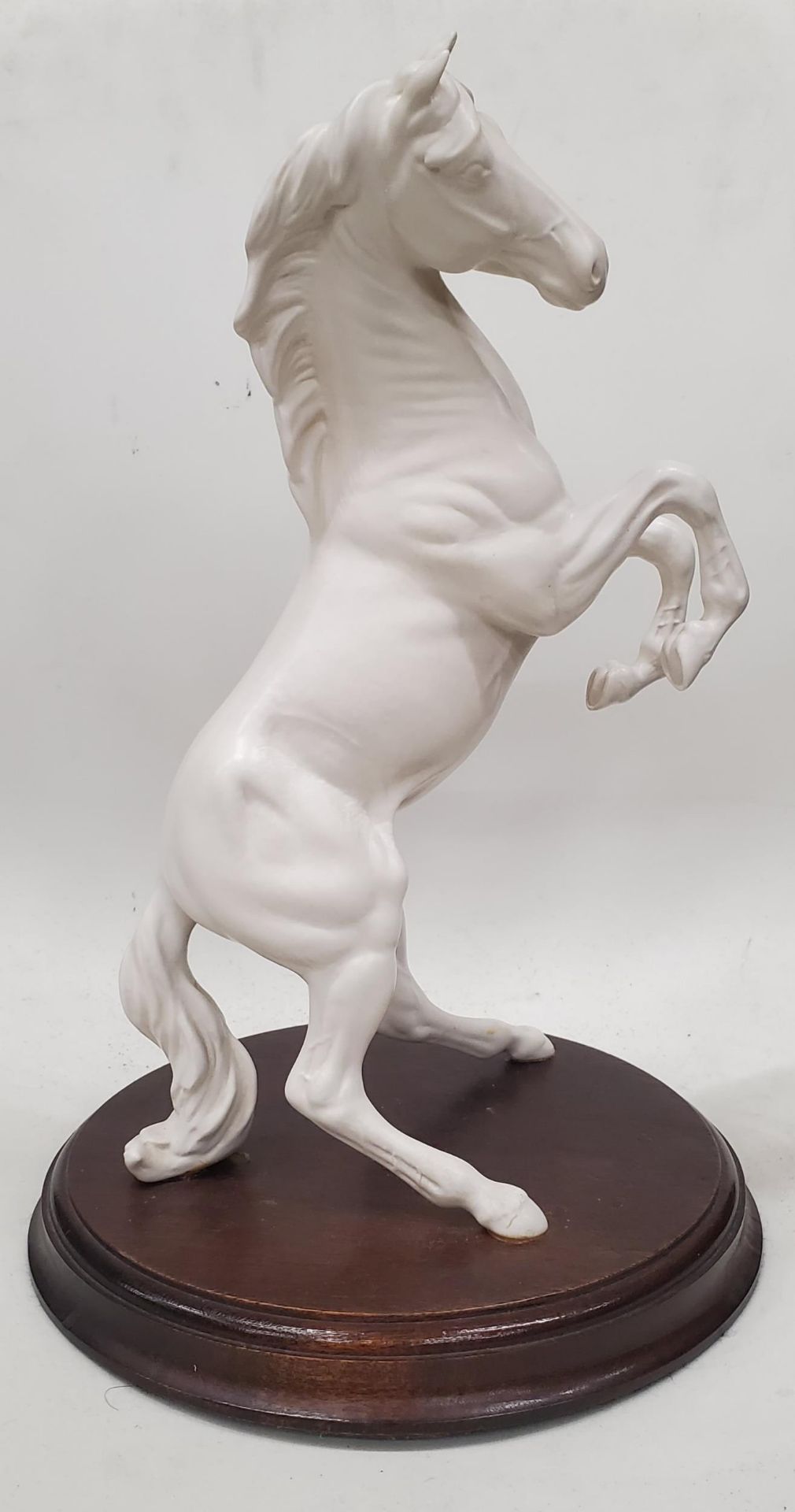 A BESWICK/DOULTON REARING WHITE HORSE ON A WOODEN PLINTH, HEIGHT 30CM