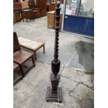 AN EARLY 20TH CENTURY OAK STANDARD LAMP WITH BARLEYTWIST AND BALUSTER COLUMN