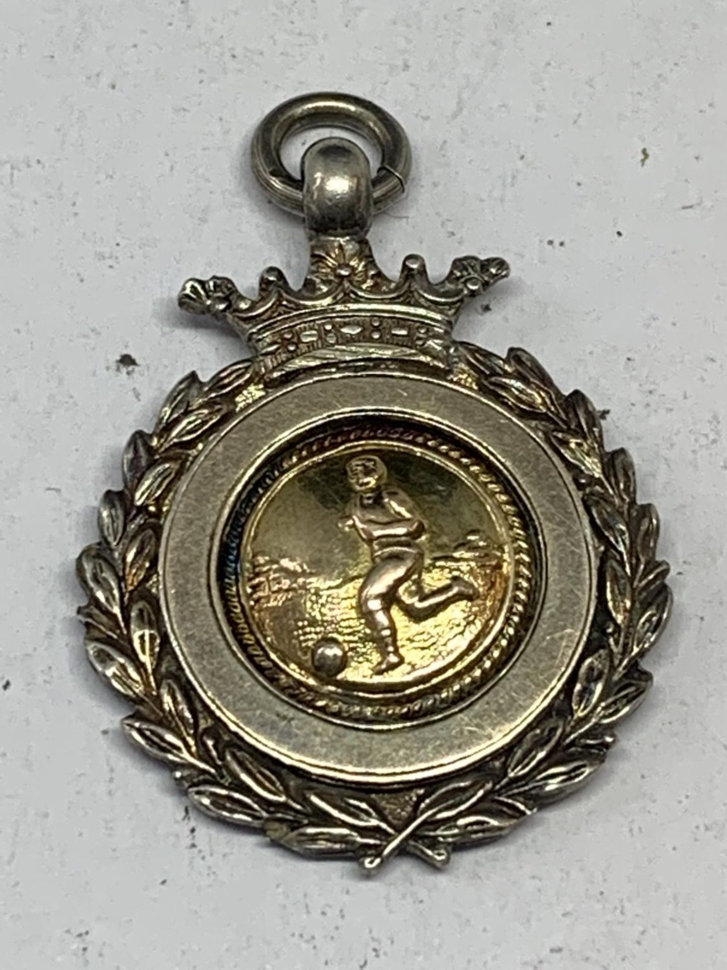 A HALLMARKED SILVER FOOTBALL MEDAL