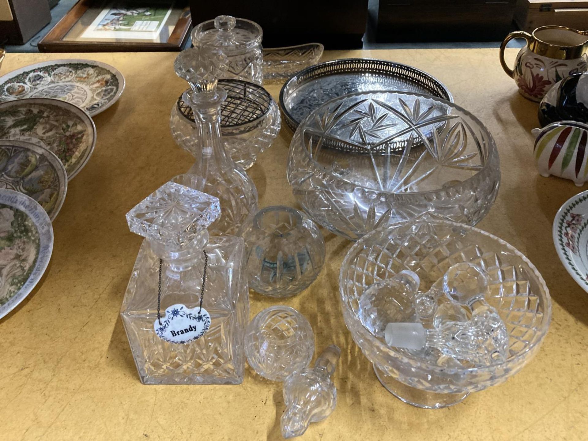 A QUANTITY OF GLASSWARE TO INCLUDE DECANTERS, BOWLS, A ROUND GALLERIED TRAY, VASES, ETC