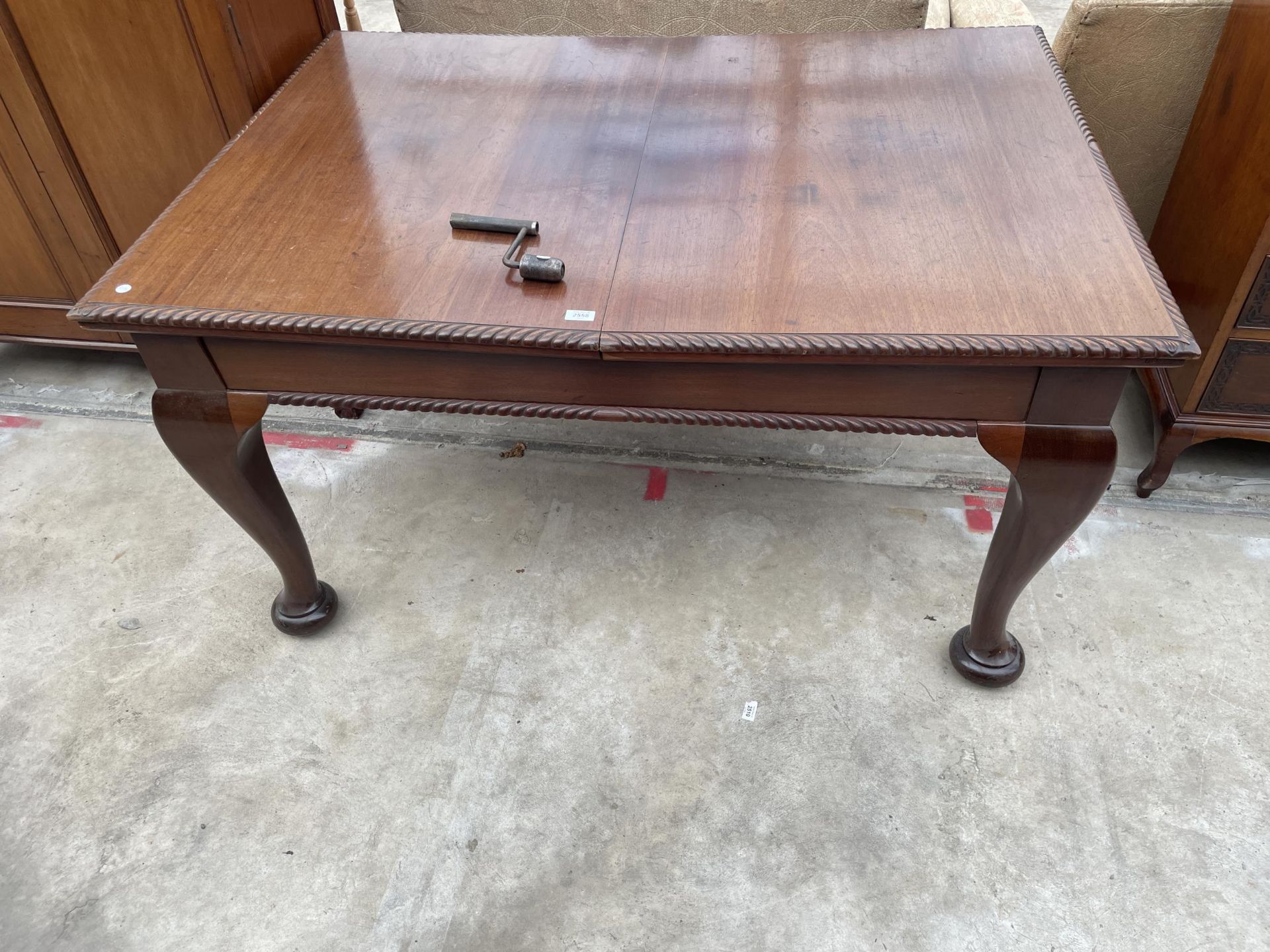 AN EARLY 20TH CENTURY MAHOGANY WIND-OUT DINING TABLE ON CABRIOLE LEGS, WITH ROPE EDGE, 57 X 41" (