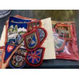 A LARGE QUANTITY OF CLOTH BADGES AND PENNANTS OF VARIOUS COUNTRIES